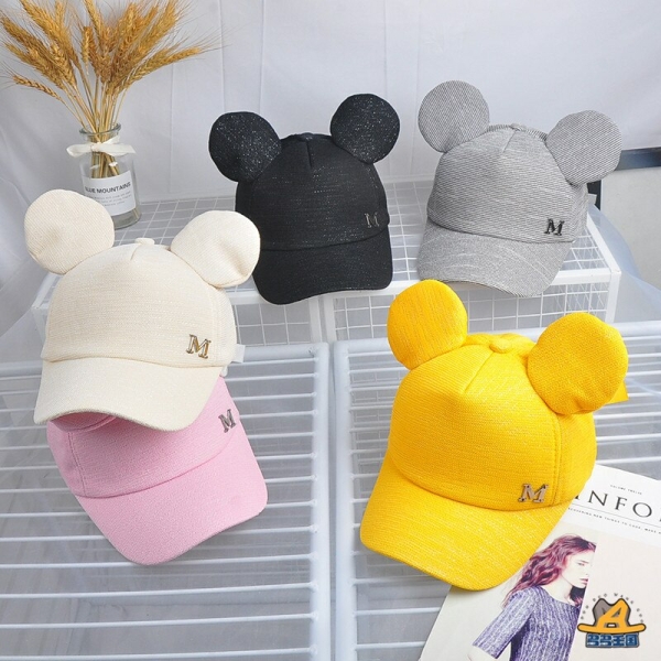 Modieuze kinderzomermutsen in verschillende kleuren op een tafel met een vaas