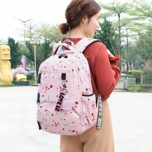 Roze schooltas met bloemmotief voor meisjes, gedragen door een meisje