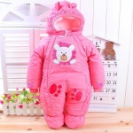 Roze meisjes jumpsuit met berenprint op een tafel voor een raam in een huis