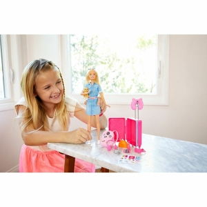 Barbiepop met hond voor meisje op een tafel in een huis