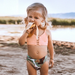 2-delig zwempak gedragen door een klein meisje op het strand.