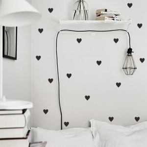 Sticker in de vorm van een zwart hart, op een muur in een huis.