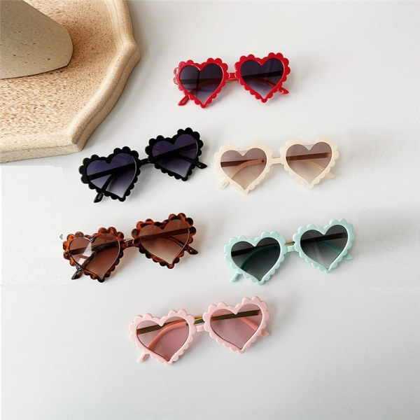 Hartvormige zonnebril op een veelkleurige tafel