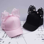 Meisjespet met zwart en roze strikje op tafel