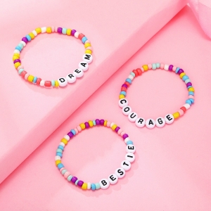 Kralen armband met gekleurde letters voor een meisje op een roze achtergrond