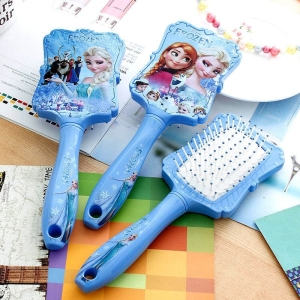 Blauwe Snow Queen haarborstel voor meisjes op een tafel met een notitieboekje
