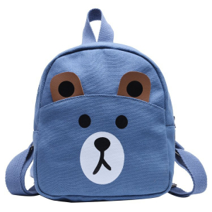 Een blauwachtige rugzak met een glanzend teddy-beigeergezicht voor meisjes. De buitenkant is licht en bruin. Hij heeft een handvat bovenop en twee schouderbanden op het tapijt.