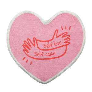 Hartvormig slaapkamerkleed voor meisjes in roze. Op de bovenkant staat een afdruk van twee handen met de woorden self love self care in rood.