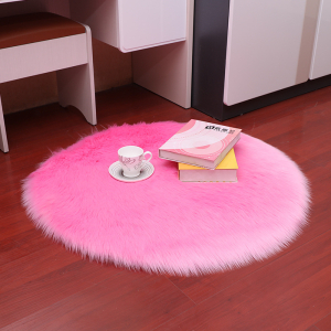 Ronde langharige faux fur deken in roze met een kopje en twee boeken erop