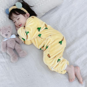 Meisje slaapt in haar gele overpyjama in een bed, met haar knuffel
