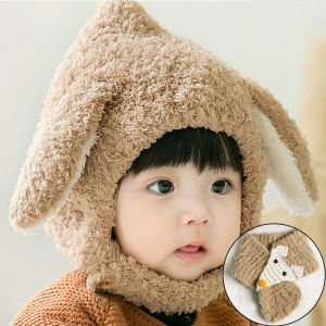 Jong bruin kind dat een beige bivakmuts met konijnenoren draagt